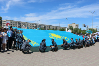 Фотография к новости: Огромный флаг Казахстана вынесли на площадь госсимволов павлодарцы