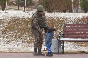 Фотография к новости: Военный жмет руку малышу. Кто они – герои полюбившегося казахстанцам фото