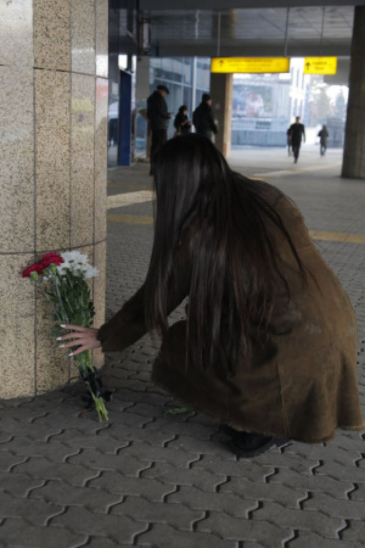 Казахстанцы несут цветы к аэропорту Алматы