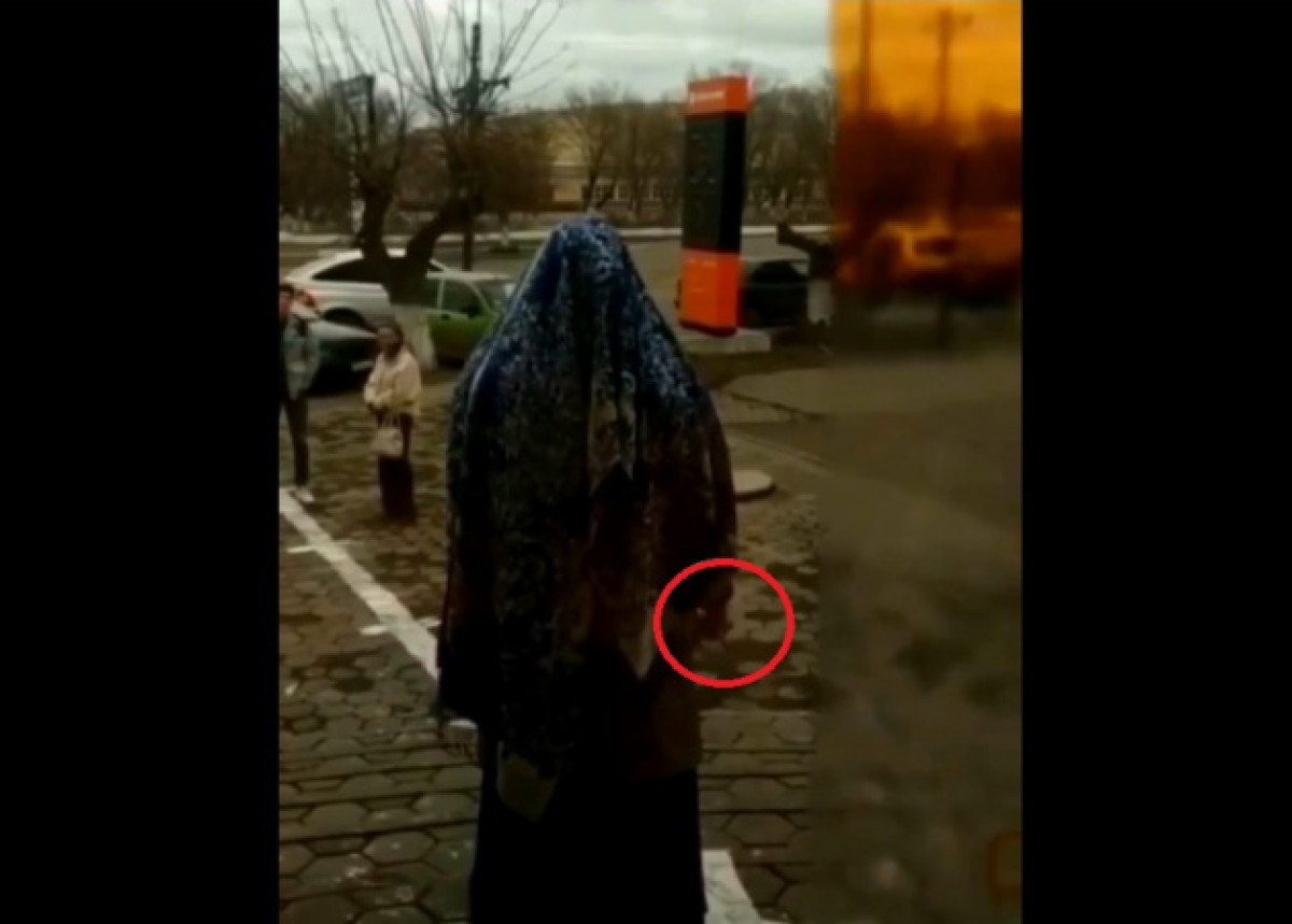 Странный ритуал у банка провела жительница Темиртау с ножом в руках