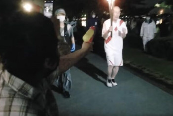 Фотография к новости: Японка пыталась затушить факел с олимпийским огнем из водяного пистолета